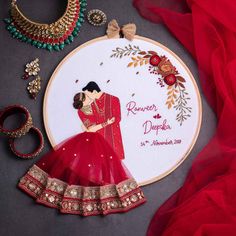 a couple in red are holding each other on the embroidery hoop with their wedding date printed on it