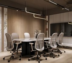 an office meeting room with white chairs and a large table in front of a flat screen tv