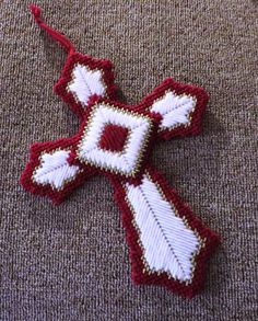 a red and white cross with an arrow on it sitting on the ground next to a piece of cloth