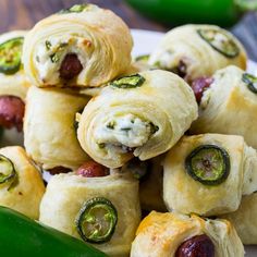 a white plate topped with rolls covered in cheese and cucumber wrapped around them