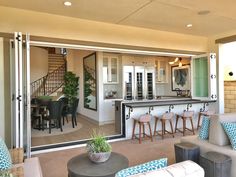 a living room filled with furniture next to a kitchen