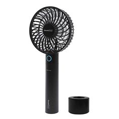 a black portable fan sitting on top of a white table next to a cup holder