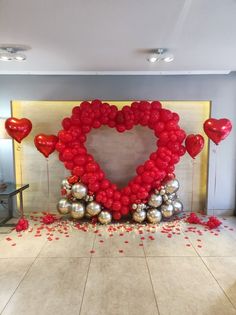 a heart - shaped balloon arrangement with red and silver balloons