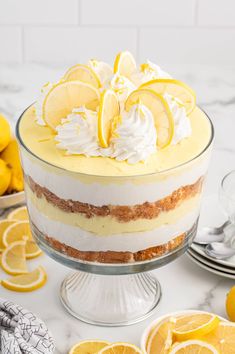 there is a cake with lemons and whipped cream in the center on a table