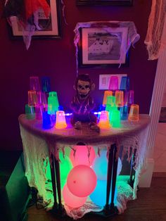 a table topped with lots of glasses and a clown head on top of it's side