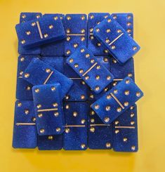 blue squares with gold rivets are arranged on a yellow surface