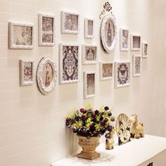 there are many frames on the wall with flowers and vases in front of them