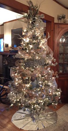 a white christmas tree with clear lights in a living room