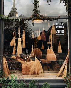 brooms are displayed in the window of a store