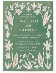 a green wedding card with white flowers and leaves on the front, in gold foil