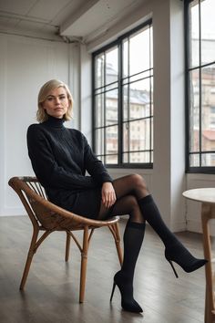 a woman sitting in a chair with her legs crossed