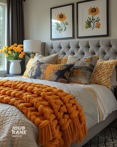 a bedroom with sunflowers on the window sill and pictures above the bed