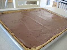 a chocolate cake sitting on top of a metal pan covered in frosted icing