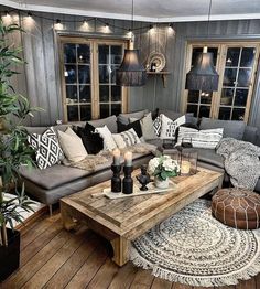 a living room filled with lots of furniture and pillows on top of a wooden floor