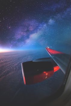 the view from an airplane window looking at the night sky and stars in the distance