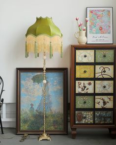 a lamp sitting on top of a table next to pictures