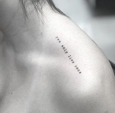 the back of a woman's shoulder with an inscription on it