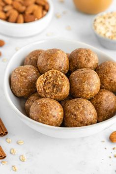 a white bowl filled with almonds next to cinnamon sticks