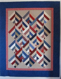 a quilted wall hanging on the side of a white wall with blue and red strips