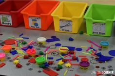 plastic bins filled with different colored objects on top of a table next to each other