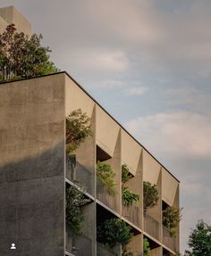 an apartment building with plants growing on the balconies