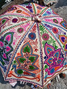 an open colorful umbrella sitting on the ground