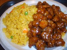 a white plate topped with meat and rice