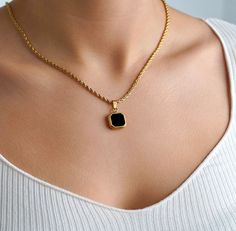 Luxury 18K Gold Onyx Necklace in either a Gold / Silver Charm Model is wearing a 20" chain. Created using real cuts of an onyx stone. Every stone is unique making this the perfect gift/ present. We have also added the option to purchase the black enamel pendant for those who want a cheaper option than the black onyx gemstone. If you select with a chain, the standard chain is a 22" rope chain. You can see in some of the images the pendant is on a different chain. If you would like a different cha Luxury Black Chain Necklace For Gift, Black Jewelry With Gold Chain For Gift, Black Necklace With Gold Chain For Gift, Onyx Pendant Necklace For Gift, Elegant Yellow Gold Onyx Necklaces, Onyx Necklace With Large Pendant For Gift, Luxury Modern Onyx Necklace, Elegant Hand-strung Onyx Necklace, 18k Gold Necklace