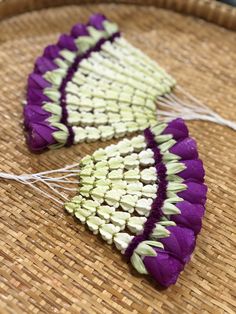 two pieces of purple and white fabric sitting on top of a woven basket