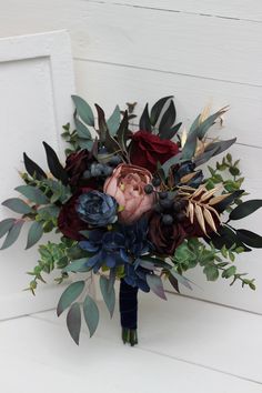 the bridal bouquet is made up of flowers and greenery