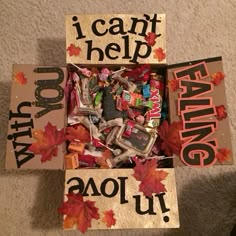 a box filled with candy and candies on top of a floor next to a sign that says i can't help