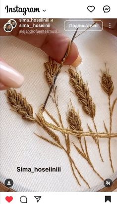 someone is working on some kind of art project with yarn and thread in the shape of wheat stalks