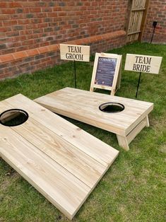 two wooden cornholes sitting on top of grass next to signs that read team groom