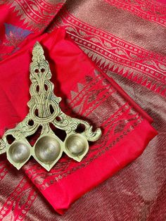 two metal spoons sitting on top of a red cloth