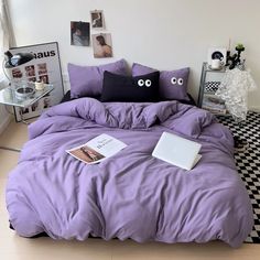 a bed with purple sheets and two eyes drawn on the pillow cases, in front of a black and white checkered floor