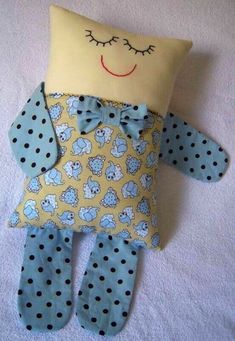 a stuffed animal that is laying down on a bed with polka dot pants and a pillow