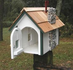 a dog house with a stone wall and roof in the middle of a wooded area