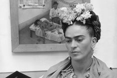 a black and white photo of a woman with flowers in her hair