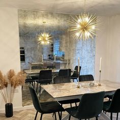 a dining room table with black chairs and a chandelier