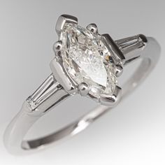 an oval cut diamond ring with baguettes on the side and tapered shoulders