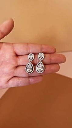 Our Gorgeous HOPE Simulated Diamond Drop Earrings with tear drop shaped diamonds. The HOPE Earrings can be styled with most of our wedding headpieces, Bridal Tiaras and Crowns. These are perfect for adding a delicate touch of sparkle. Handcrafted with Highest Quality CZ Crystals Platinum plated Guards against scratches and tarnish. Approx. Length 1" Approx. Width 0.5" Nickel free Complete This Look: AURORA Swarovski Regular Crown Diamond White Teardrop Chandelier Earrings For Anniversary, Hand Set Diamond Teardrop Bridal Earrings, Teardrop Diamond White Chandelier Earrings With Elegant Design, Diamond Teardrop Earrings For Wedding, White Diamond-accented Teardrop Earrings For Wedding, Silver Teardrop Pendant Earrings For Wedding, White Diamond Accent Teardrop Earrings For Wedding, White Diamond Accents Teardrop Earrings For Wedding, Formal Teardrop Bridal Earrings With Diamond Accents