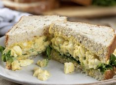 an egg salad sandwich cut in half on a plate