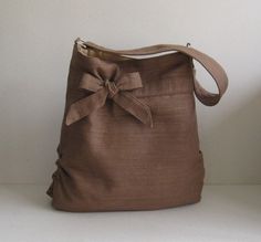 a brown bag with a bow on the front is sitting on a white table next to a lamp