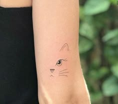 a woman's arm with a cat tattoo on the left side of her arm