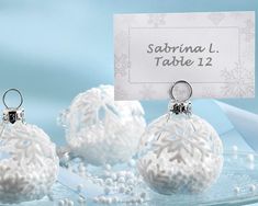 three white christmas ornaments with a place card