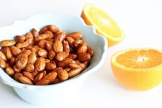 almonds in a bowl next to an orange