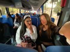 two women sitting in the back of a bus