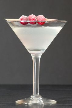 two raspberries are placed on top of the drink in a martini glass, ready to be served