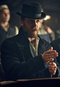 a man with a top hat sitting at a table