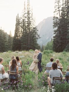 a bride and groom are kissing in the middle of an outdoor ceremony with their guests